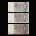 Three vintage German 20 Reichsmark banknotes are arranged vertically on a dark fabric background. Each note shows the portrait of Wilhelm Gustloff, serial numbers on the left, and ornate printed details in faded beige, brown, and gray tones.