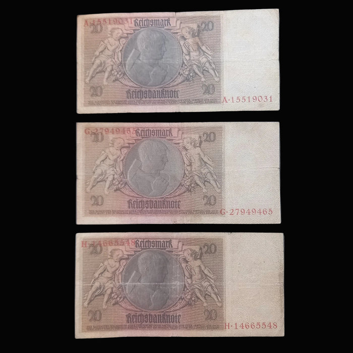 Three vintage German 20 Reichsmark banknotes are arranged vertically on a dark textured fabric background.