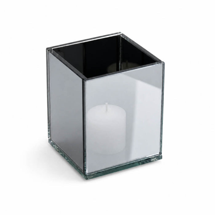 Square mirrored candle holder with white pillar candle inside, on white background