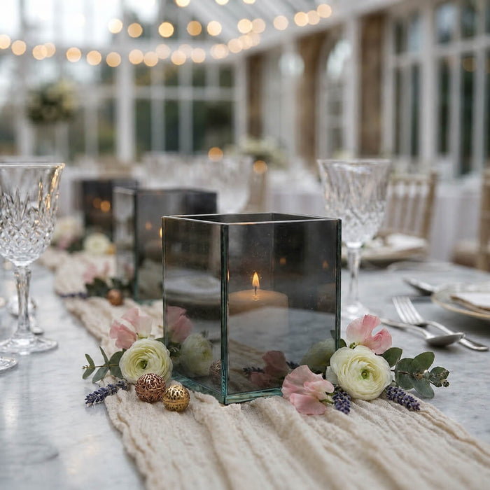 Square glass candle holders on romantic floral tablescape with lit candles