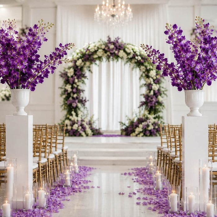 Purple silk vanda orchid sprays in white urns on pedestals along a wedding aisle