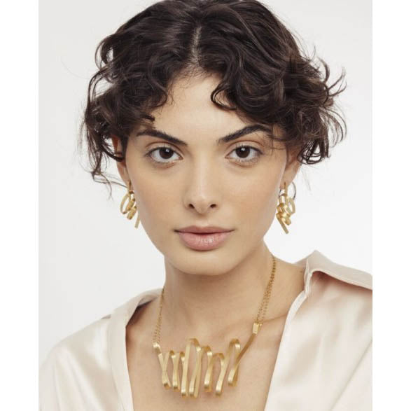 Model Wearing matching gold earrings and necklace
