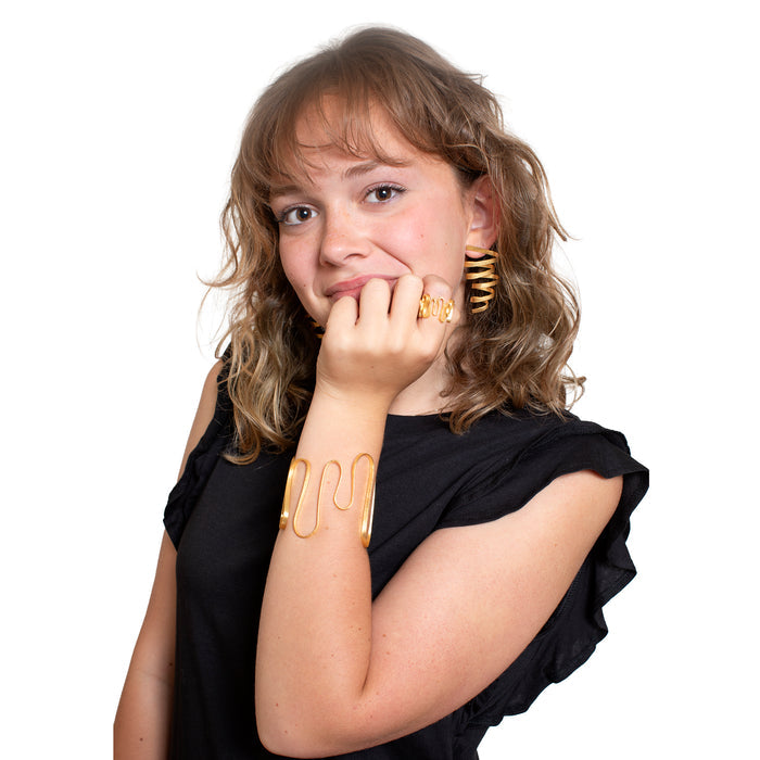 Woman wearing gold arm bands and earrings on a white background