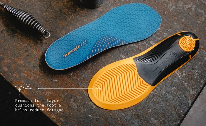 Superfeet's Work Slim-Fit Cushion Insoles on a work desk. Text reads "Premium foam layer cushions the foot & helps reduce fatigue"